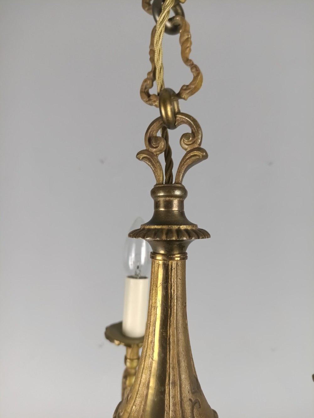A French gilt brass five-arm chandelier featuring scrolling branch arms, candle bulb sleeves, and an ornate central column. View XII