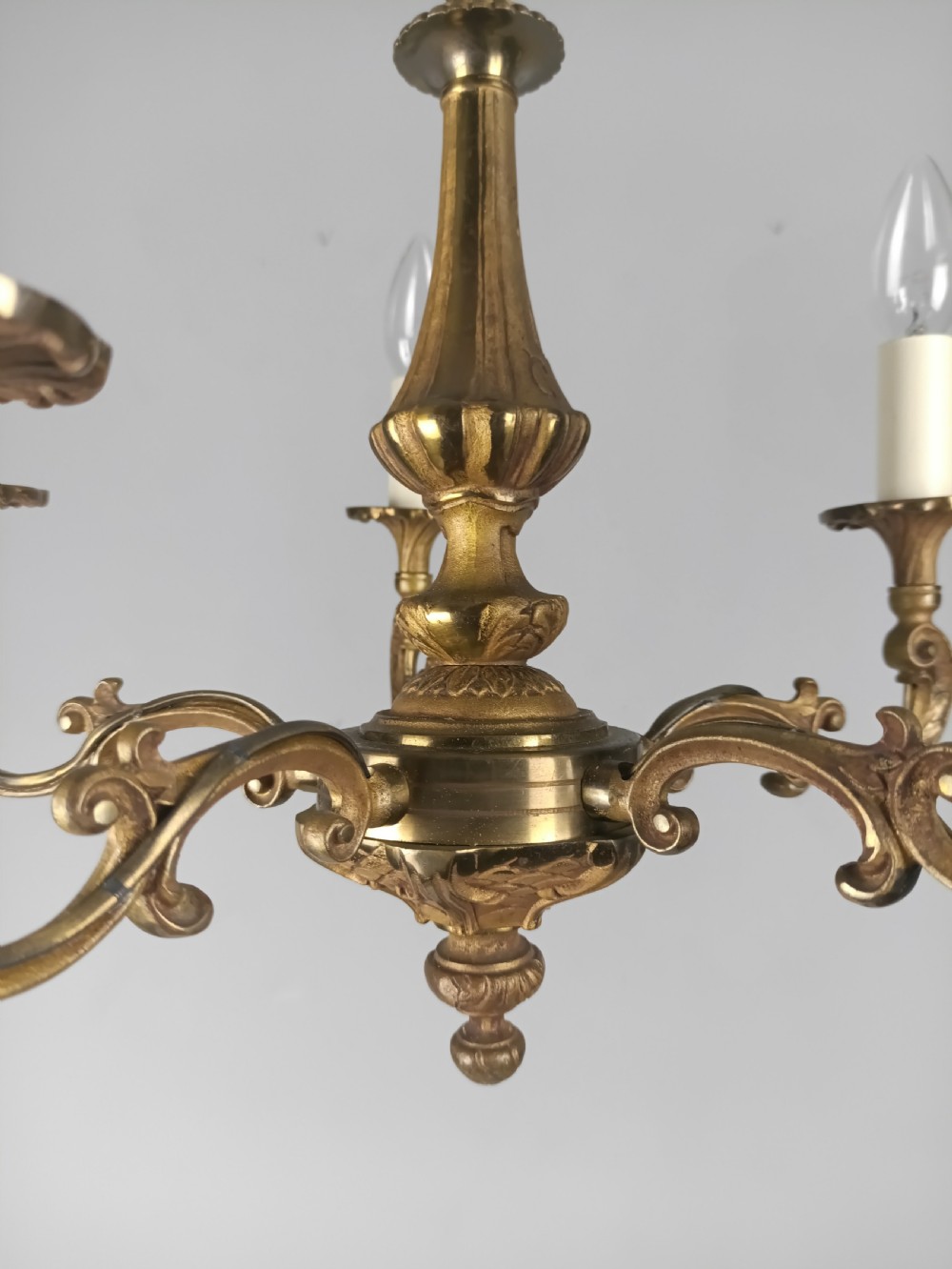 A French gilt brass five-arm chandelier featuring scrolling branch arms, candle bulb sleeves, and an ornate central column. View XIV