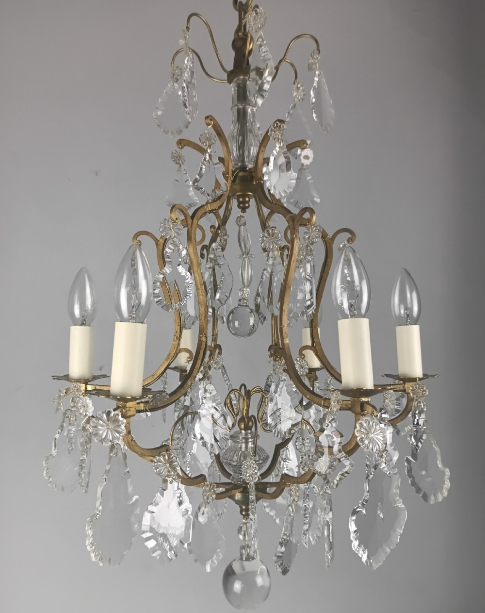 An antique French six-light birdcage chandelier featuring a gilded frame hung with clear crystal drops and glass rosettes. View II