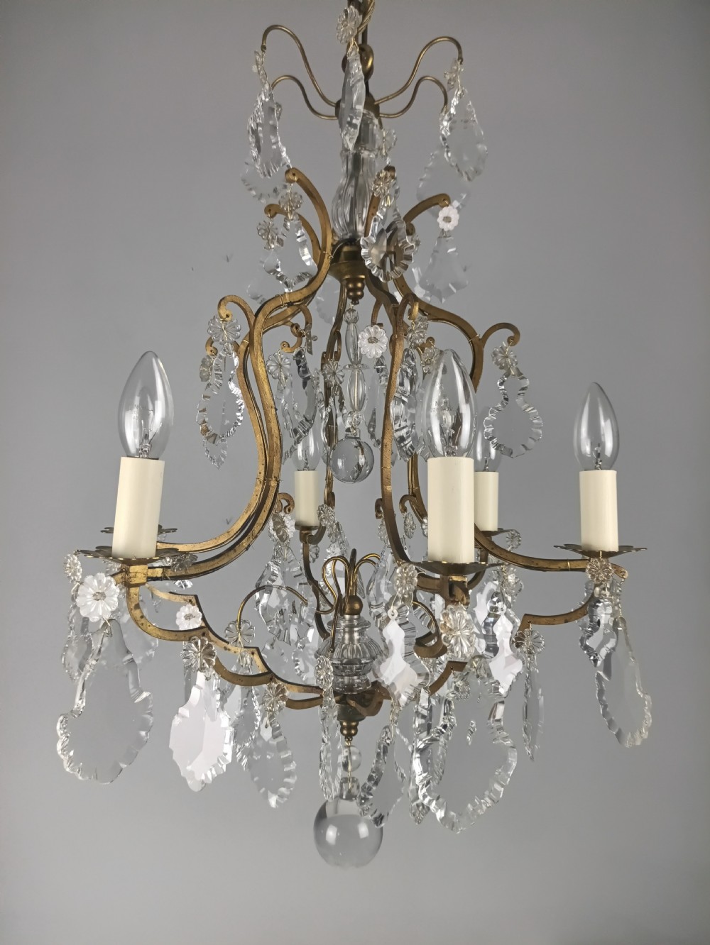 An antique French six-light birdcage chandelier featuring a gilded frame hung with clear crystal drops and glass rosettes. View XI
