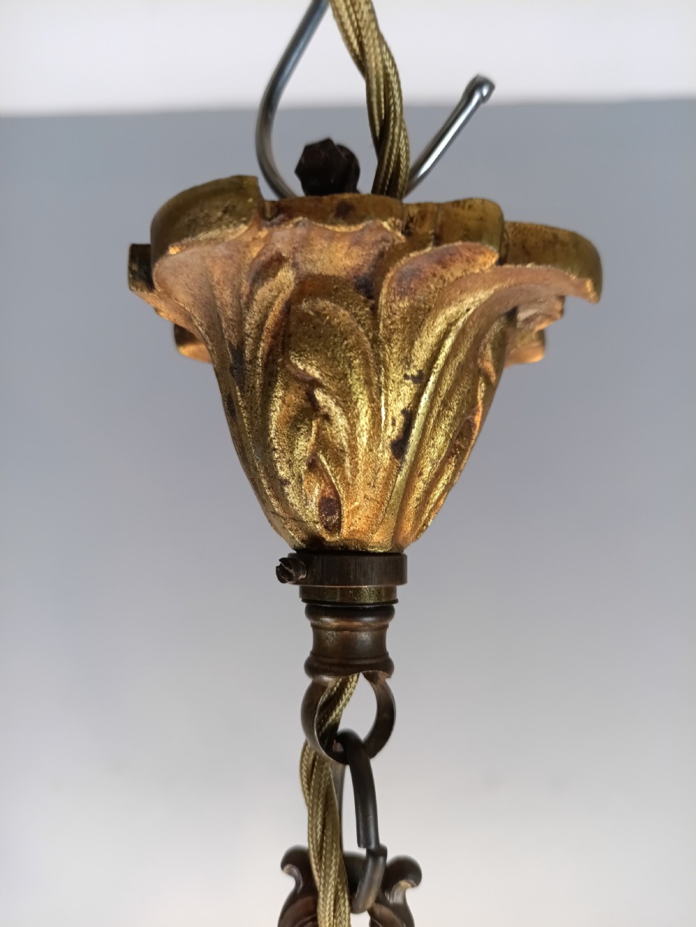A French five-light gilded brass frame chandelier featuring scrolled arms, candle sleeves, and suspended cut crystal drops. View V
