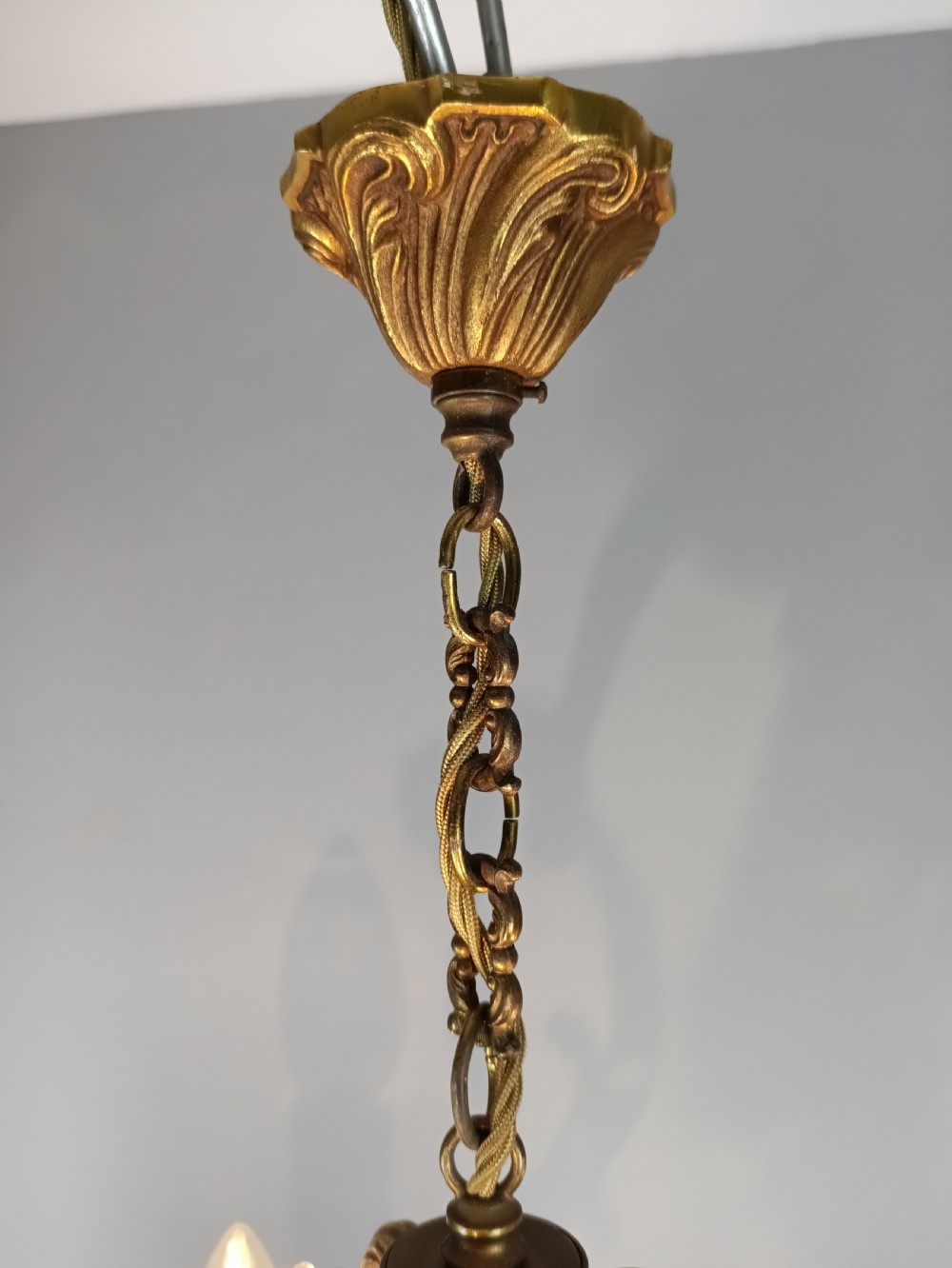 A French Rococo style three-light gilded brass chandelier decorated with suspended cut crystal drops and candle-effect light holders. View VII