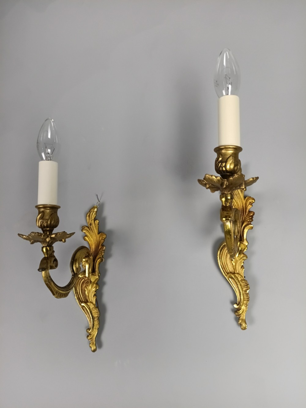A pair of French gilt brass single-arm wall lights with acanthus leaf backplates and candle bulb fittings. View III