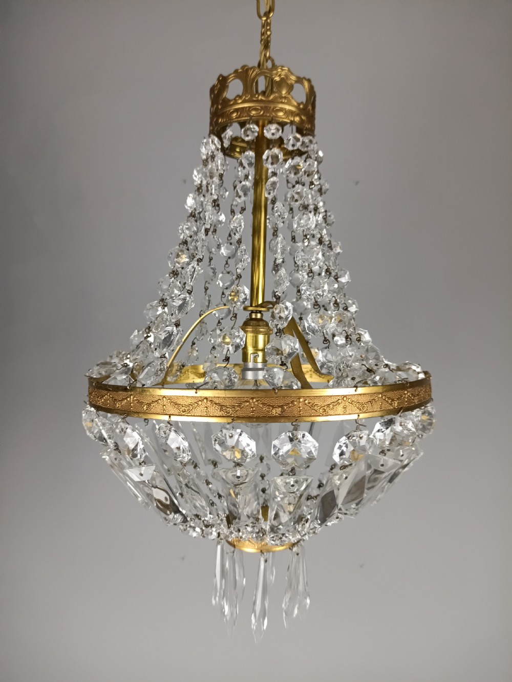 An antique French tent and bag chandelier featuring cascading crystal beads attached to a decorative brass rim with cut glass prisms below. View V
