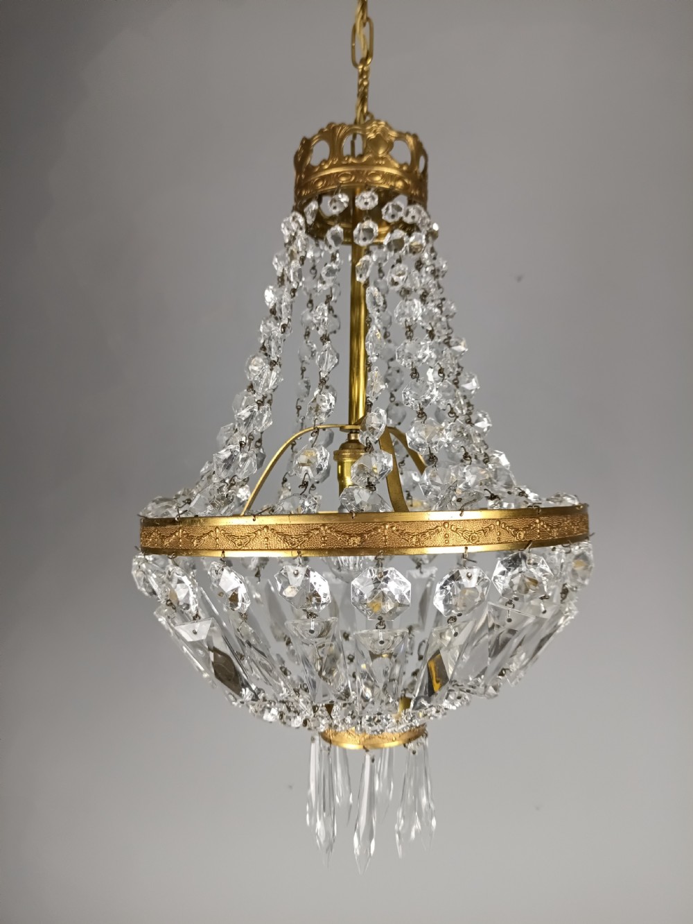 An antique French tent and bag chandelier featuring cascading crystal beads attached to a decorative brass rim with cut glass prisms below. View VII