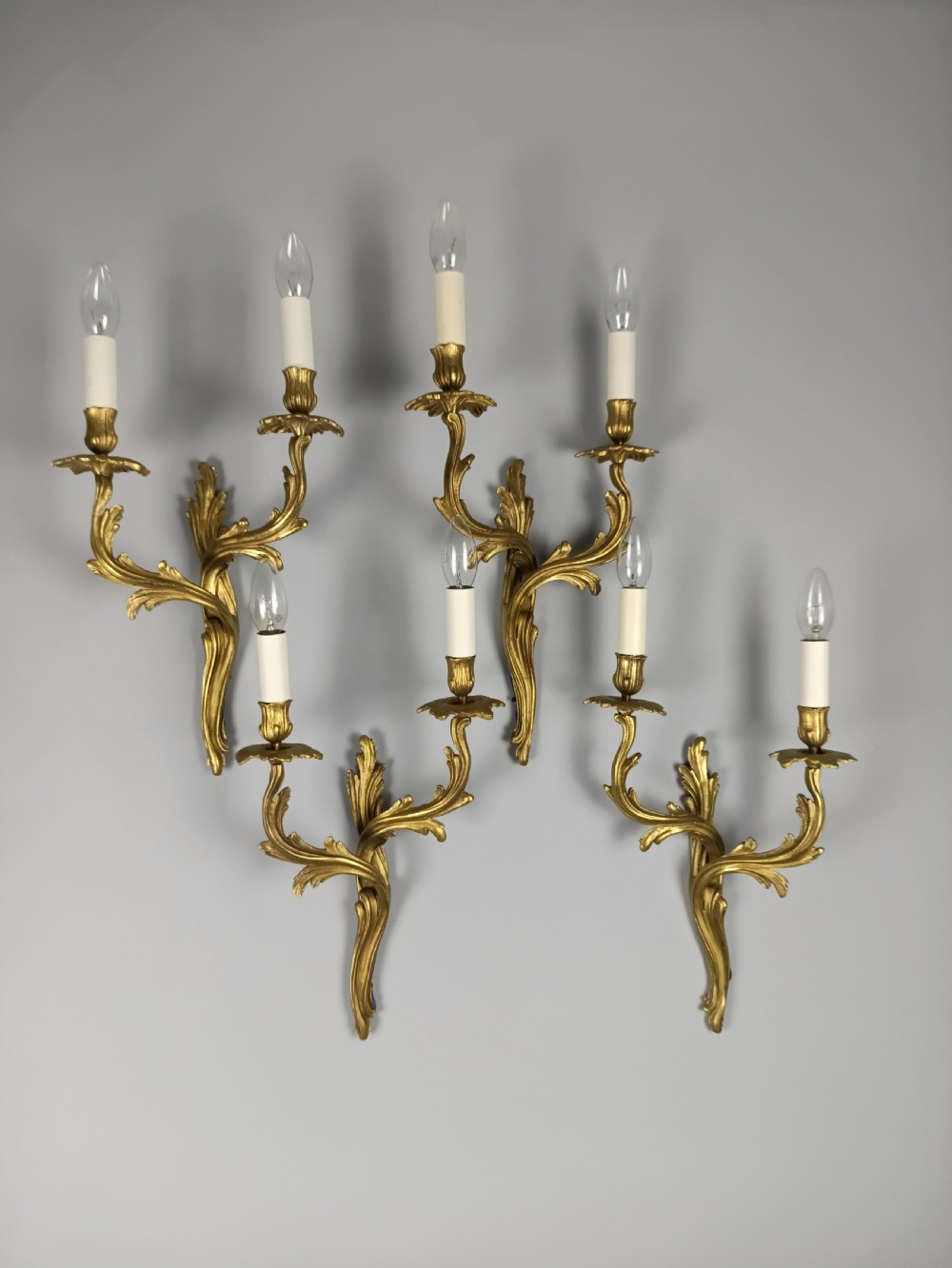 Set of four French Rococo style gilt brass twin-arm wall sconces featuring acanthus leaf motifs. View II