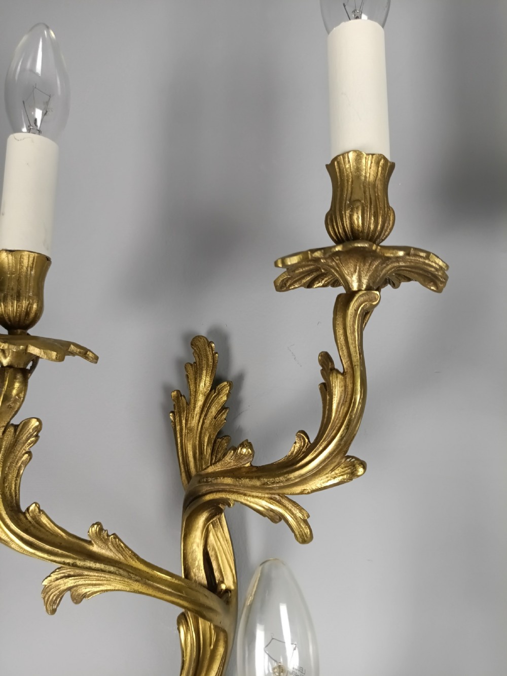 Set of four French Rococo style gilt brass twin-arm wall sconces featuring acanthus leaf motifs. View III