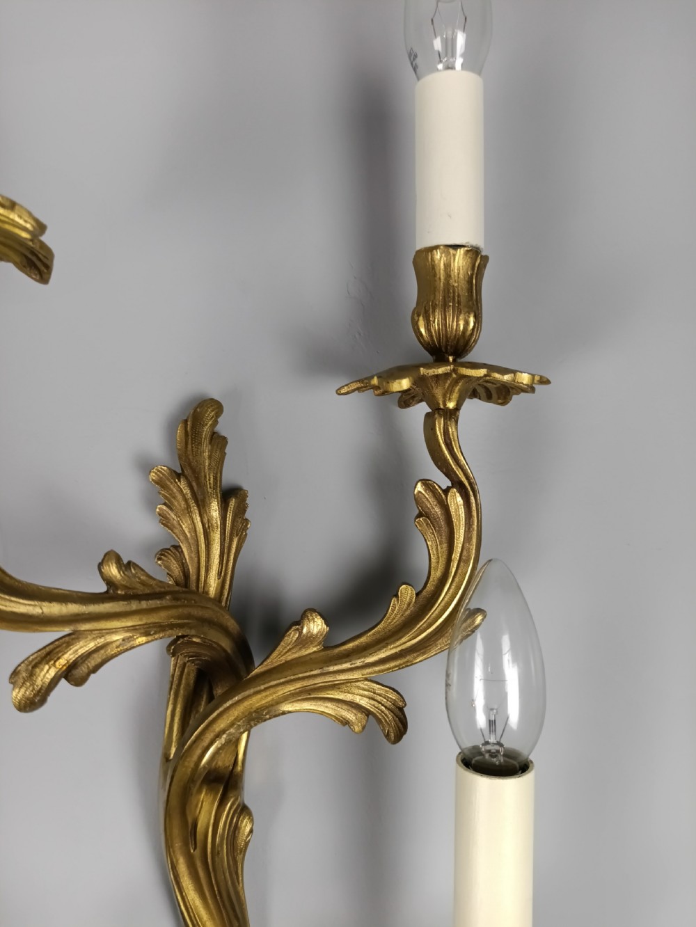 Set of four French Rococo style gilt brass twin-arm wall sconces featuring acanthus leaf motifs. View IV