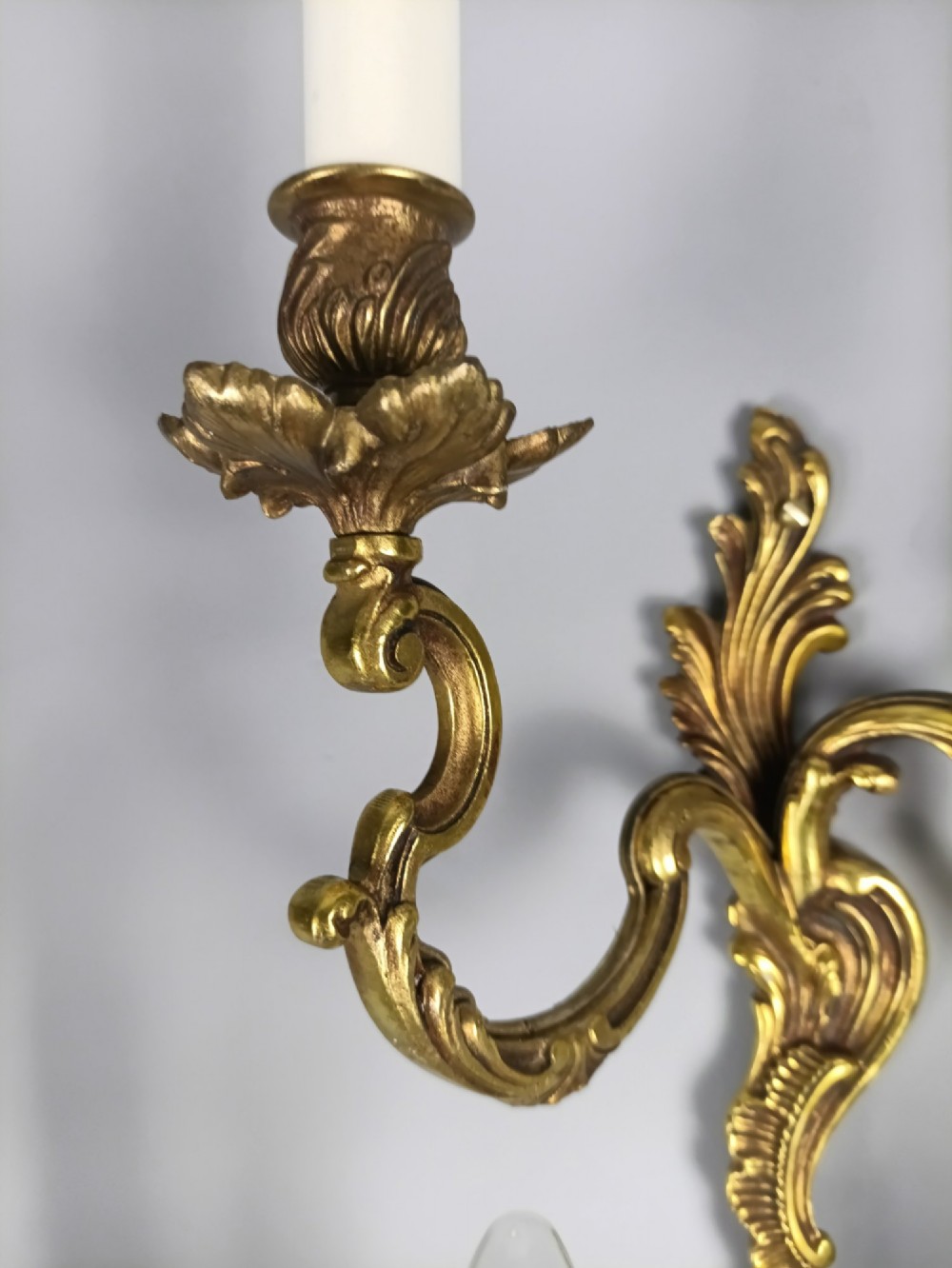 A set of three French antique gilded bronze twin-arm wall sconces featuring acanthus leaf scrolling motifs and candle sleeves. View IV