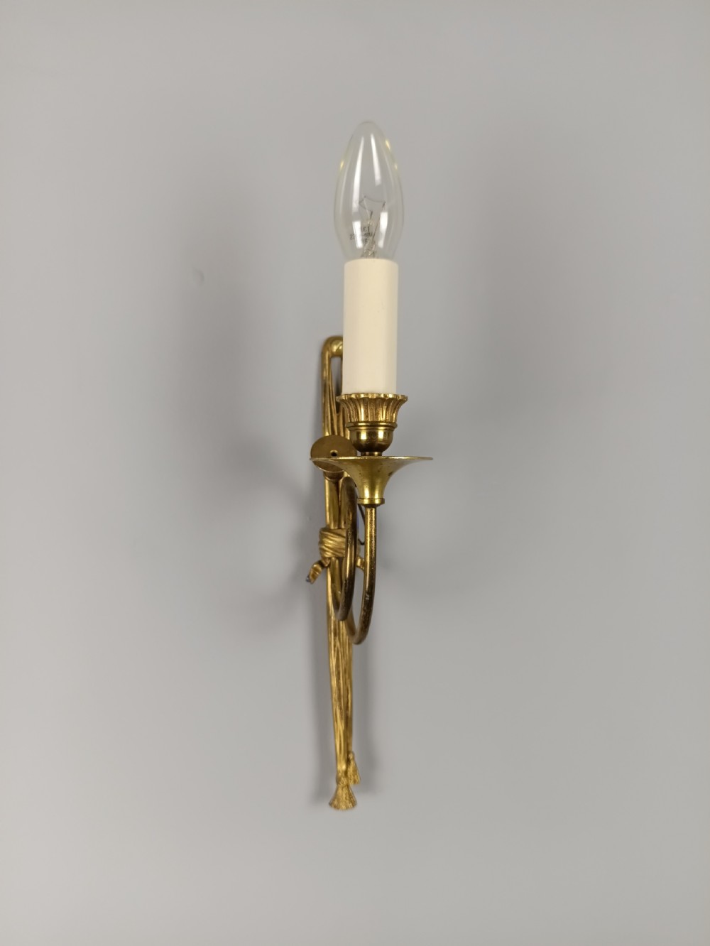 A single-arm French antique Louis XVI style wall sconce crafted from gilded brass with a horn motif arm and a white candle sleeve. View IV