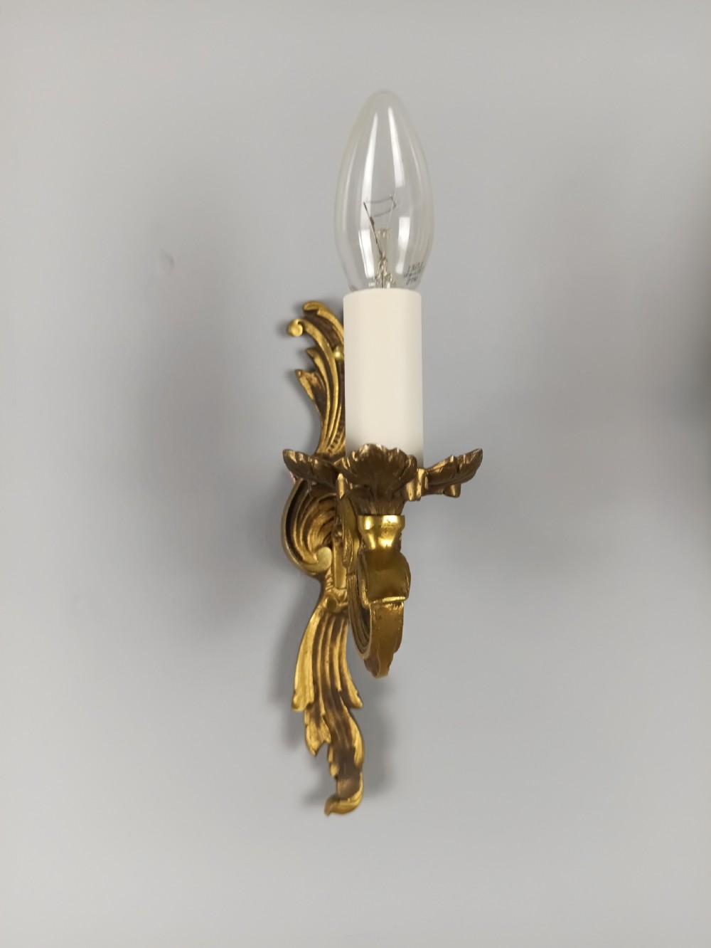 A pair of French Rococo style gilded bronze single-arm wall sconces featuring acanthus leaf scrollwork and candle-form sockets. View VI