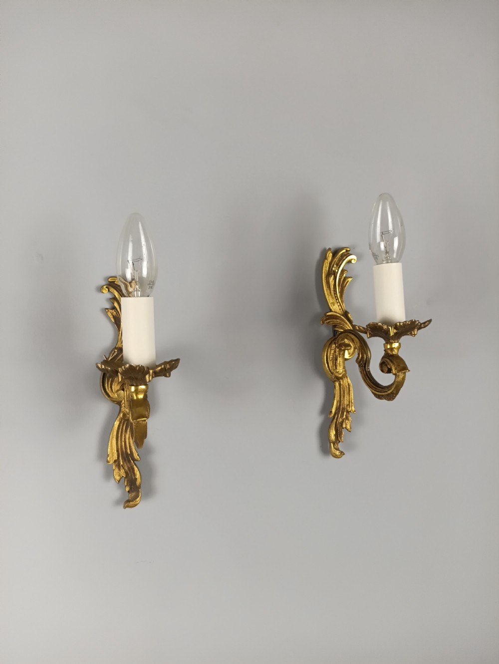 A pair of French Rococo style gilded bronze single-arm wall sconces featuring acanthus leaf scrollwork and candle-form sockets. View VII
