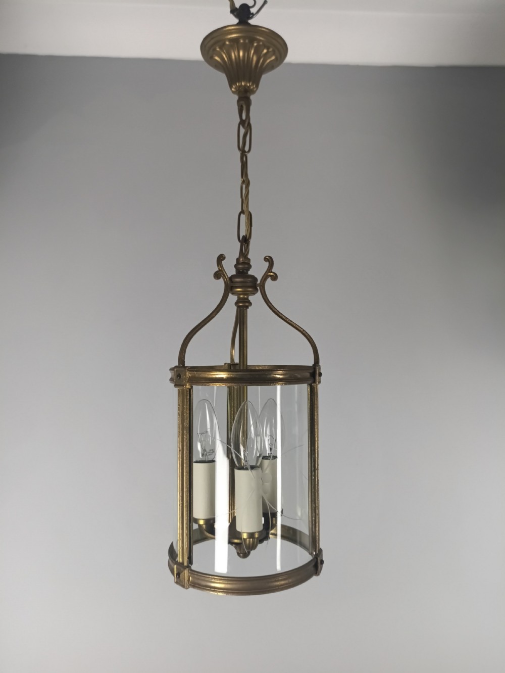 A cylindrical French gilt brass hall lantern with etched curved glass panels housing a three-bulb candle fitting. View III