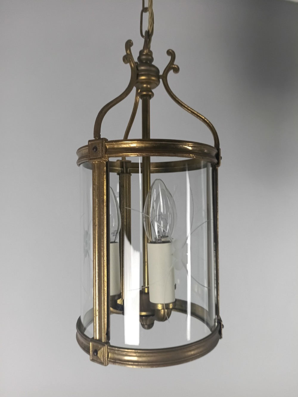 A cylindrical French gilt brass hall lantern with etched curved glass panels housing a three-bulb candle fitting. View IV