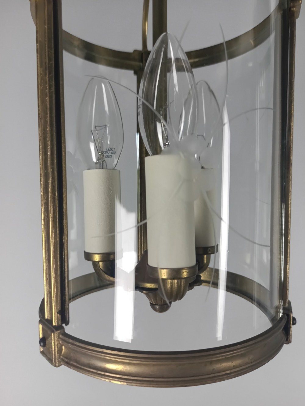 A cylindrical French gilt brass hall lantern with etched curved glass panels housing a three-bulb candle fitting. View V