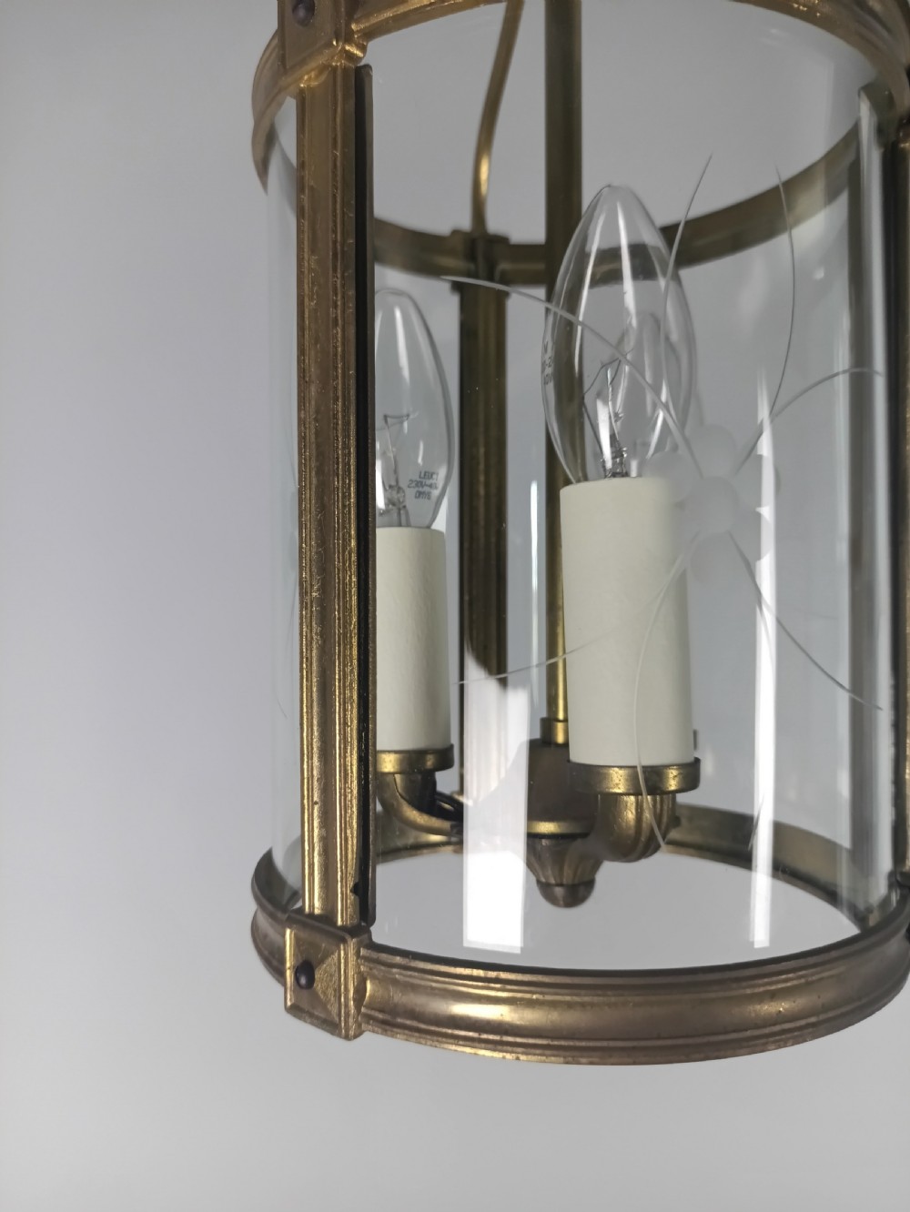 A cylindrical French gilt brass hall lantern with etched curved glass panels housing a three-bulb candle fitting. View VII