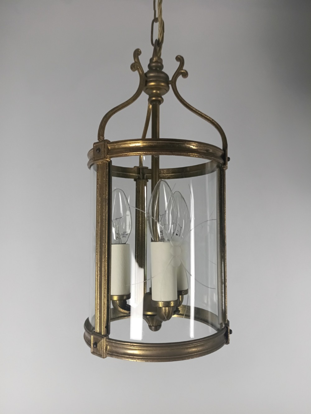 A cylindrical French gilt brass hall lantern with etched curved glass panels housing a three-bulb candle fitting. View VIII