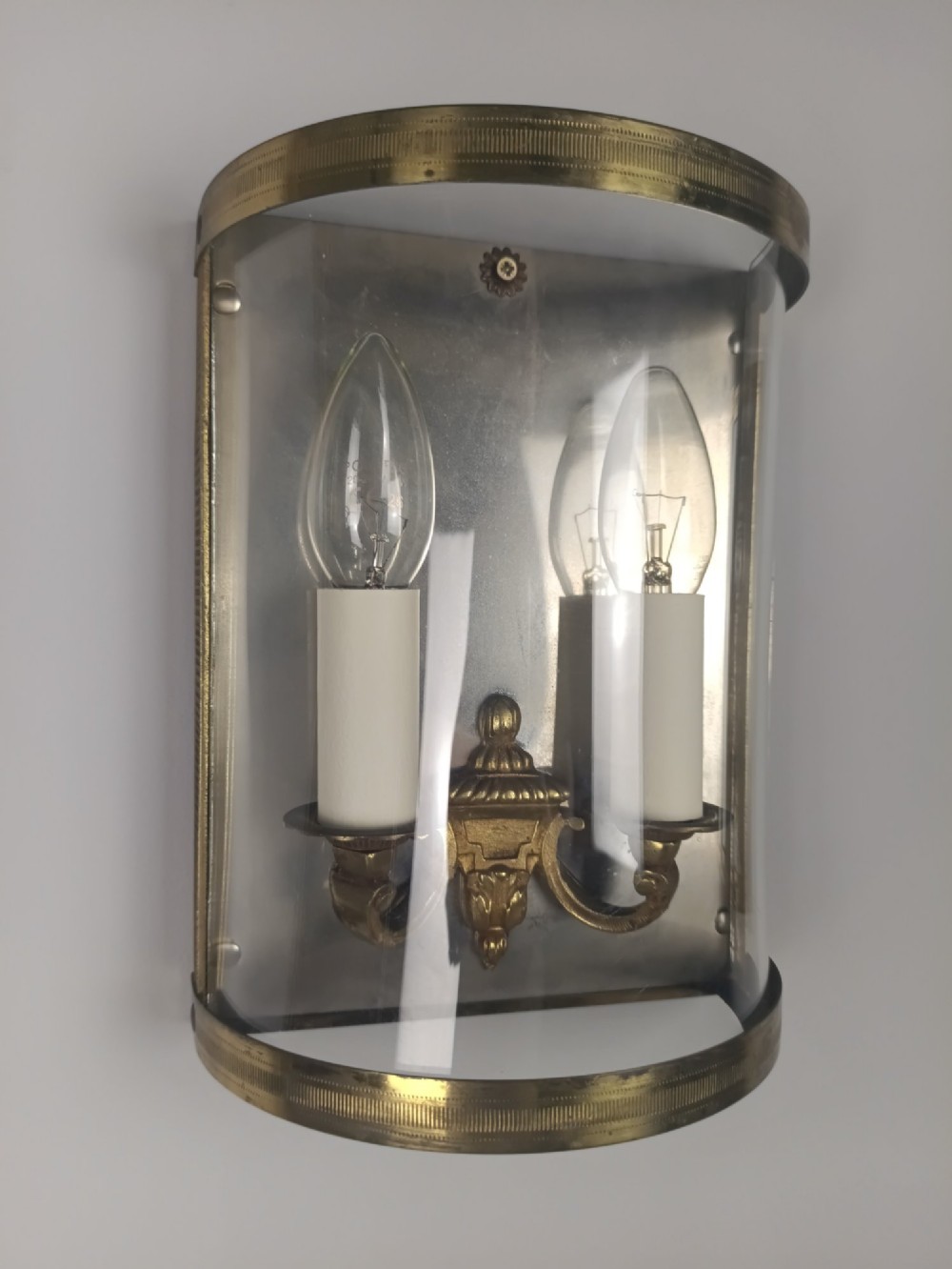 A pair of French gilt brass half-lantern wall lights featuring curved clear glass panels and twin candle-style sockets. View VI