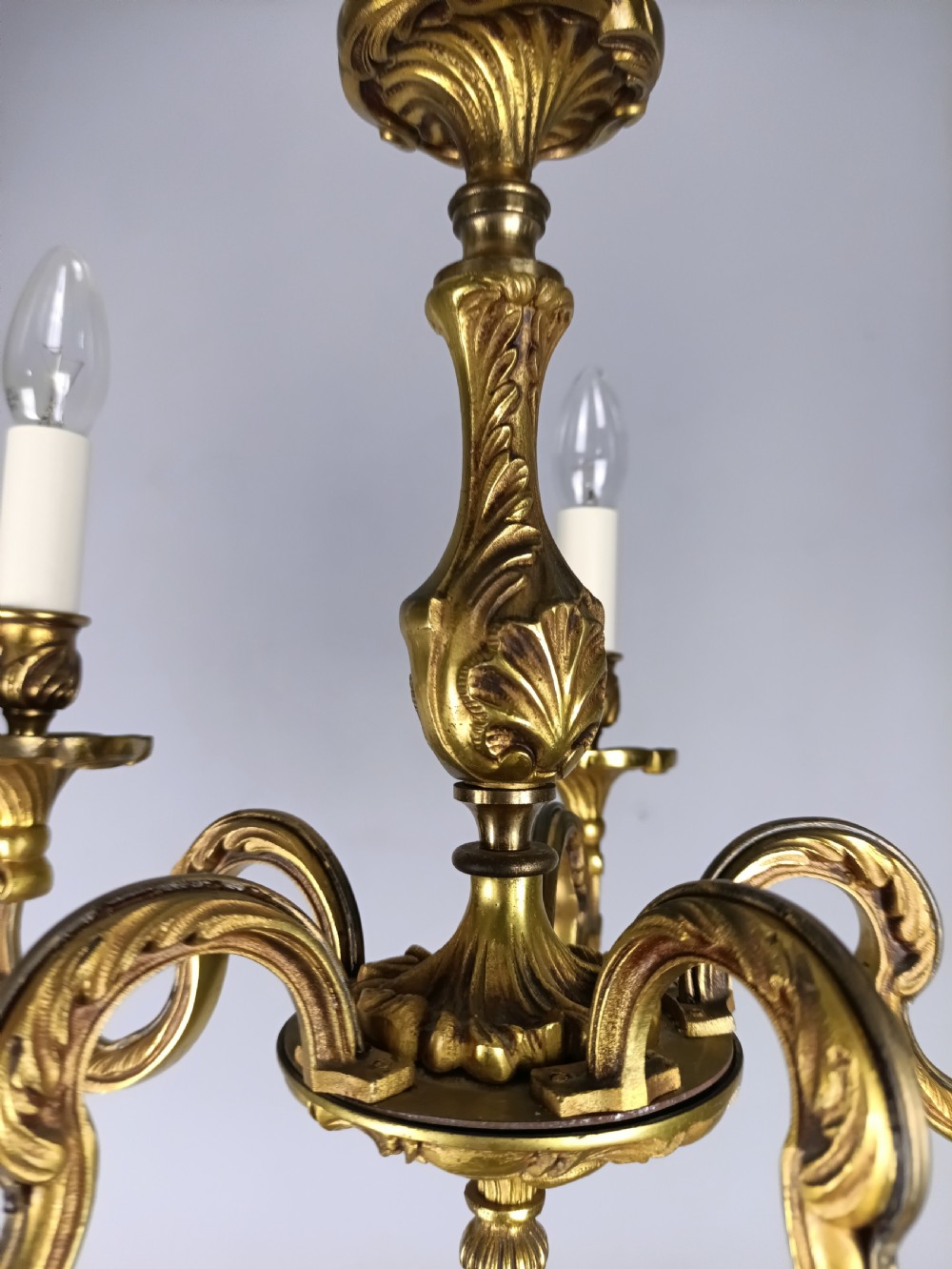A five-arm French gilt bronze chandelier featuring acanthus leaf scroll arms, candle-style sockets, and an ornate central column suspended by a chain. View IV