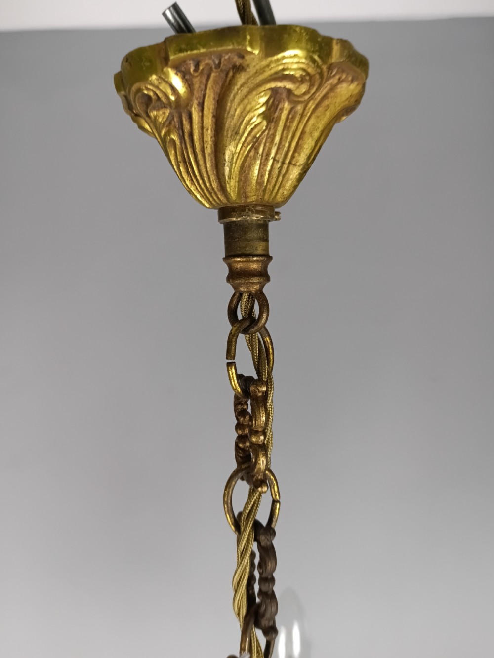 A five-arm French gilt bronze chandelier featuring acanthus leaf scroll arms, candle-style sockets, and an ornate central column suspended by a chain. View VII