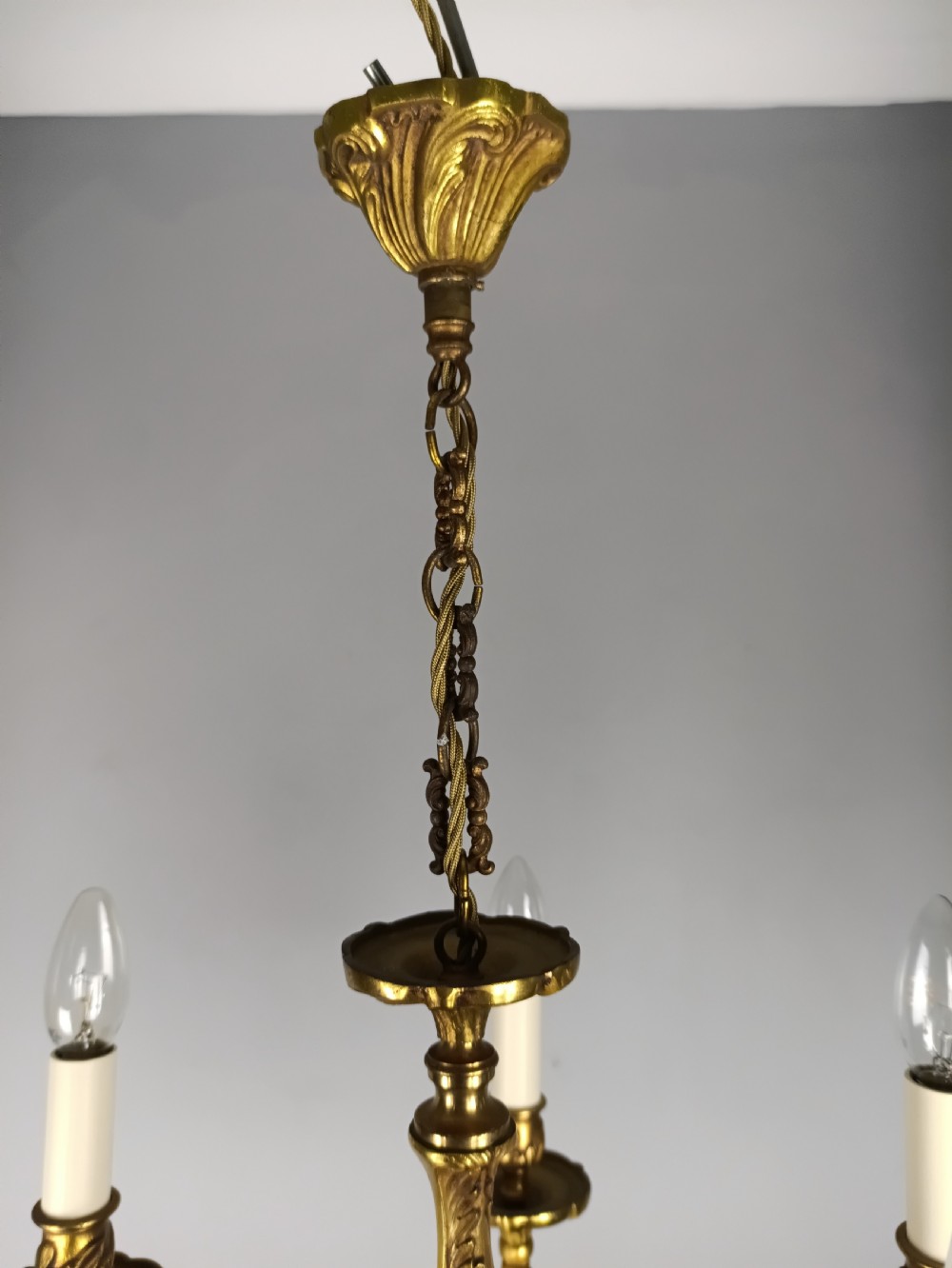 A five-arm French gilt bronze chandelier featuring acanthus leaf scroll arms, candle-style sockets, and an ornate central column suspended by a chain. View VIII