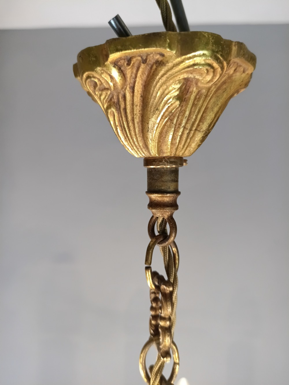 A five-arm French gilt bronze chandelier featuring acanthus leaf scroll arms, candle-style sockets, and an ornate central column suspended by a chain. View XII