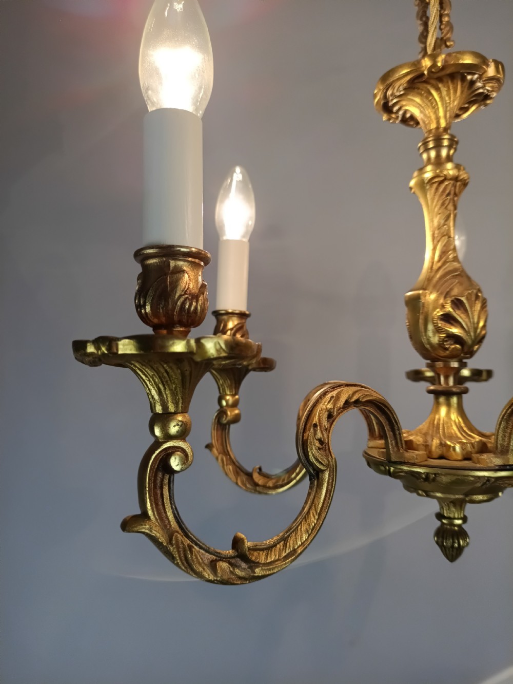 A five-arm French gilt bronze chandelier featuring acanthus leaf scroll arms, candle-style sockets, and an ornate central column suspended by a chain. View XIII