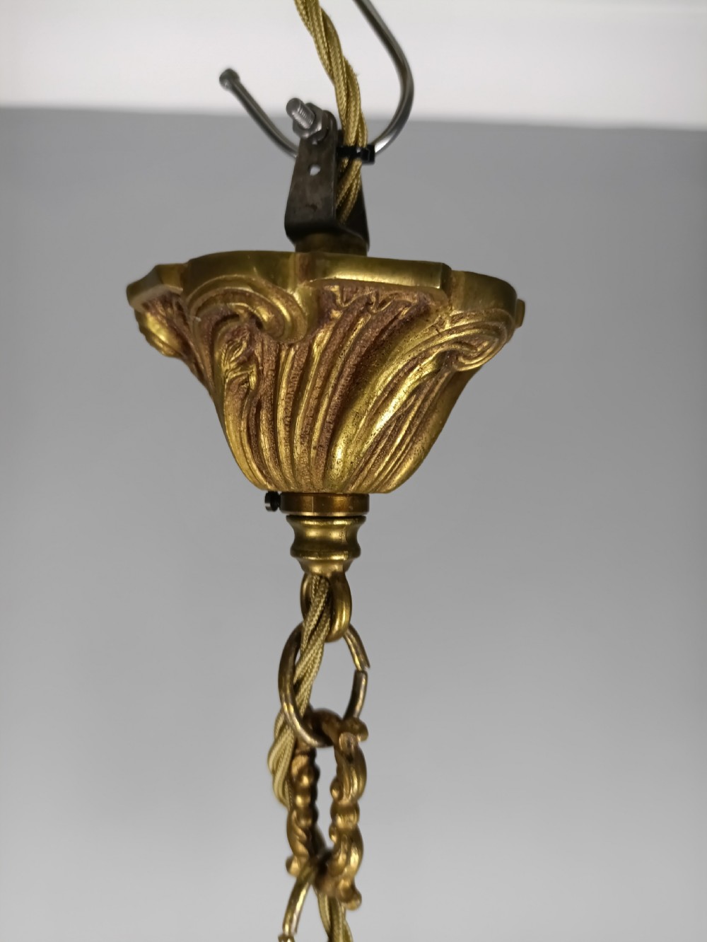 A French five-light gilt bronze birdcage chandelier featuring open rococo scrollwork arms, leafy candle drip pans, and a central open frame suspended by a chain. View IV