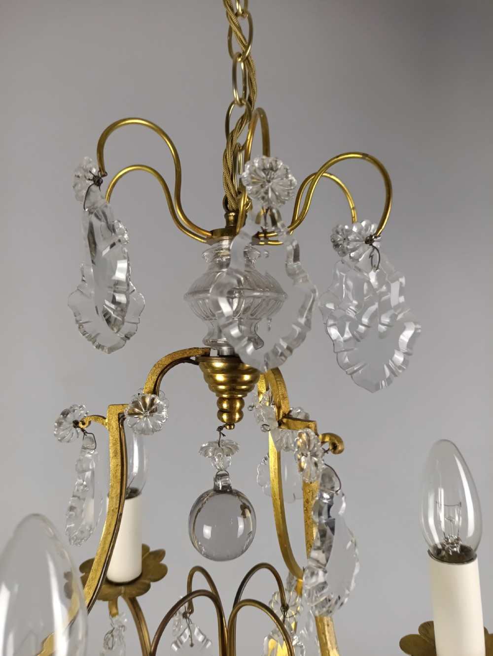 A French gilded metal three-arm birdcage chandelier with hanging clear crystal droplets and glass rosette accents. View V