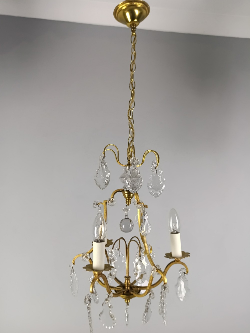 A French gilded metal three-arm birdcage chandelier with hanging clear crystal droplets and glass rosette accents. View VIII