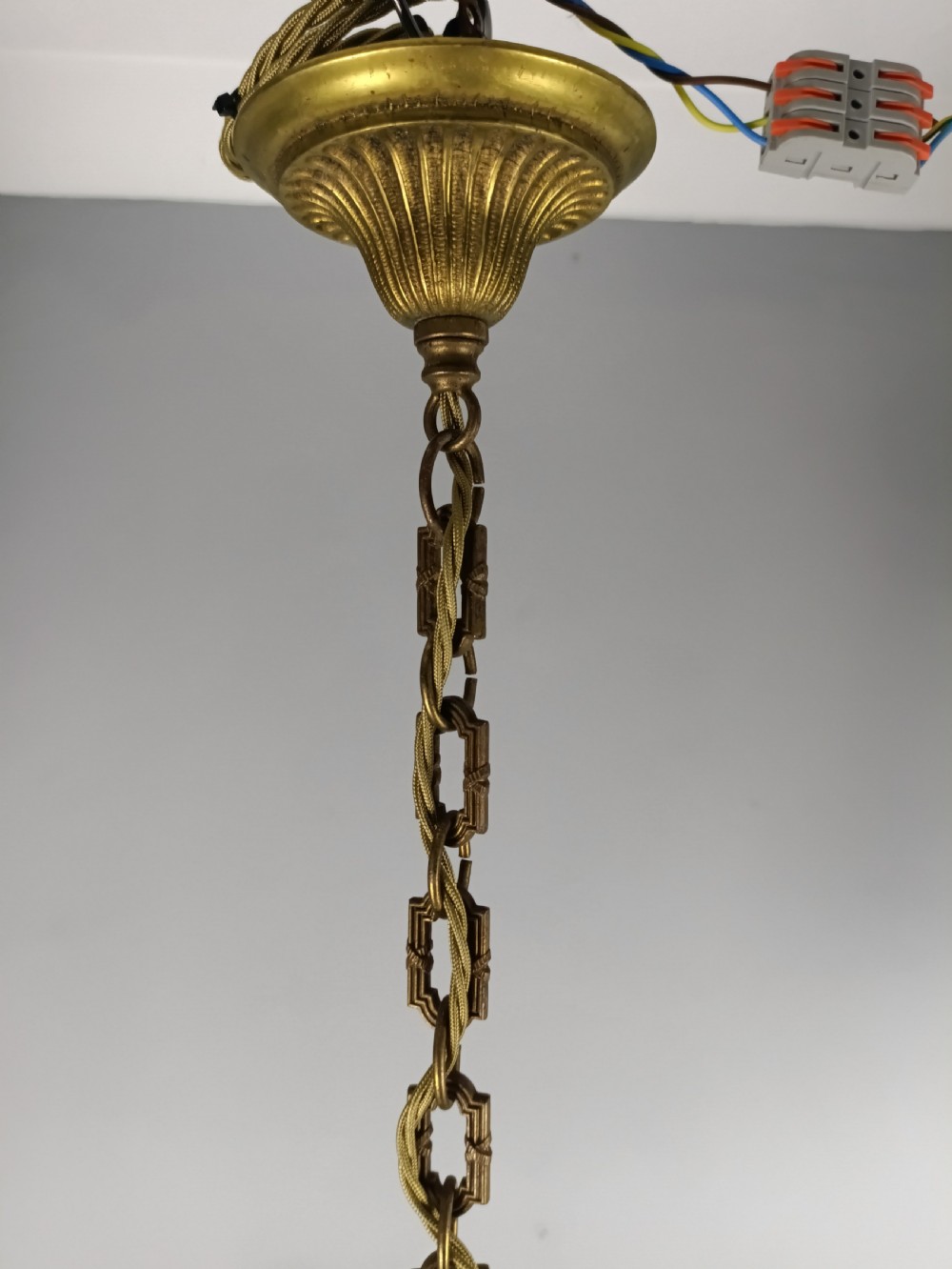 A three-arm gilt brass ceiling chandelier featuring scrolled branches, acanthus leaf decoration, and a central tapered column suspended by a chain. View XII