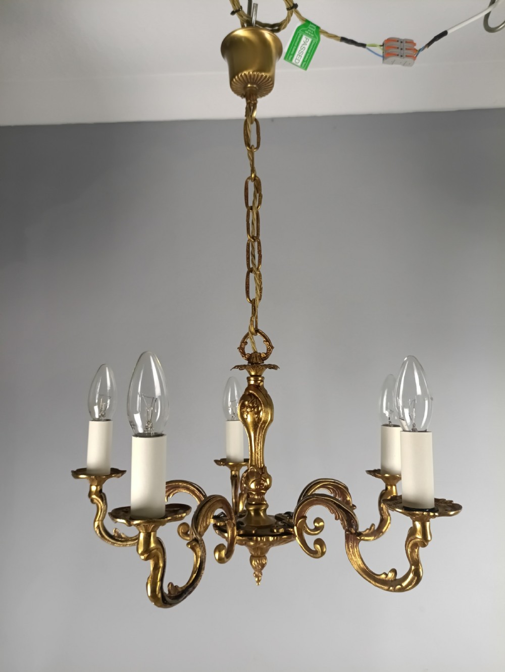 A French five-light gilt bronze chandelier featuring scrolling Rococo arms, candle-style bulb holders, and a central chased stem. View VII