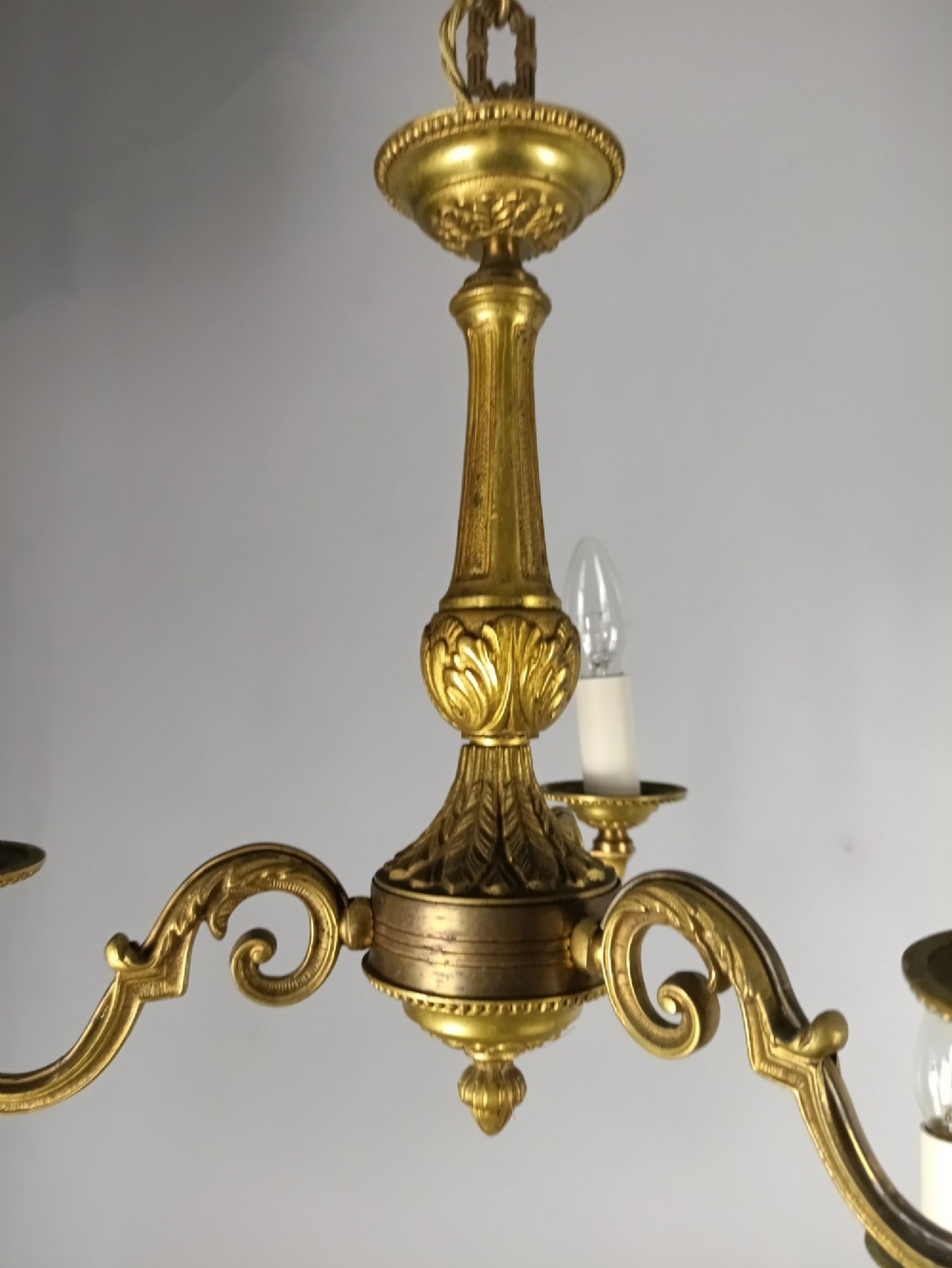 A pair of three-arm French gilt brass chandeliers featuring scrolling arms, central baluster shafts, and candle-style sockets. View VI