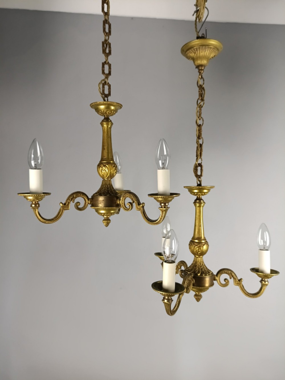 A pair of three-arm French gilt brass chandeliers featuring scrolling arms, central baluster shafts, and candle-style sockets. View VIII