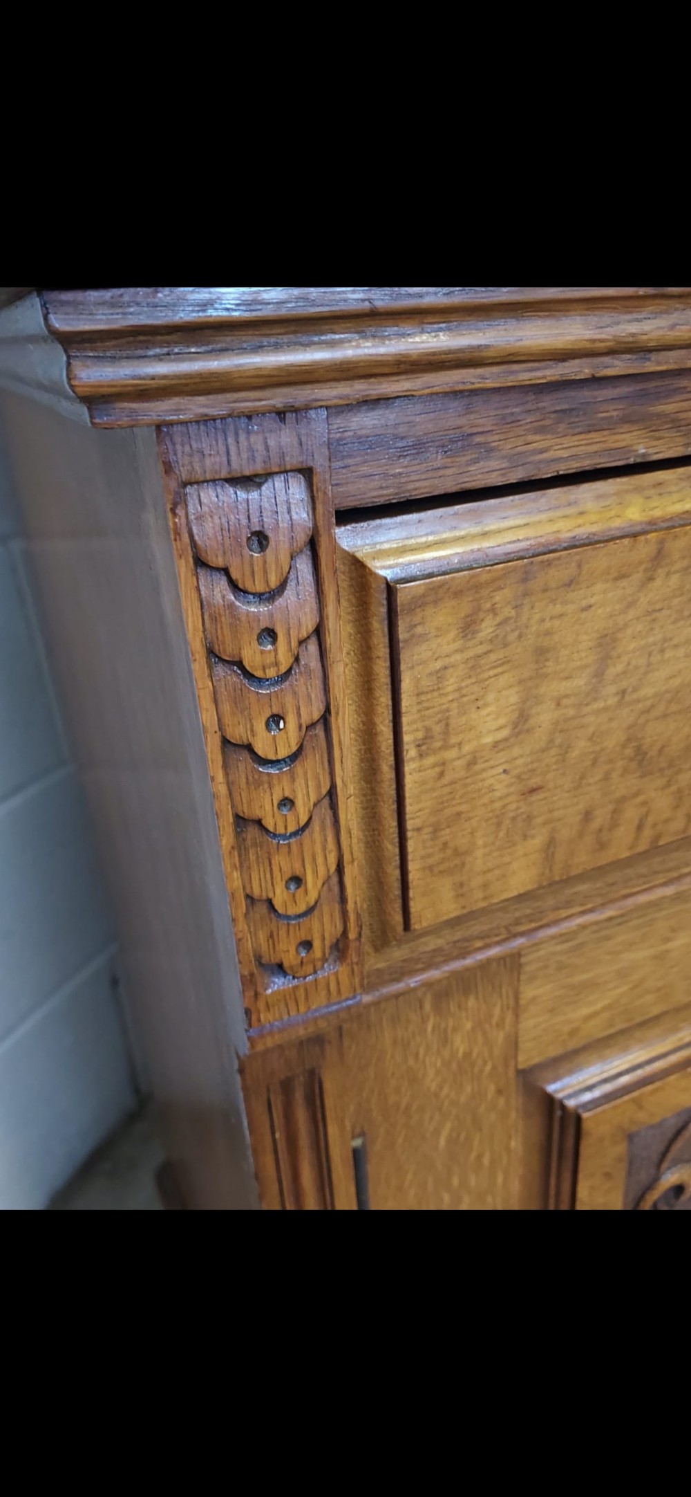 A late 19th-century oak bookcase featuring two glazed upper doors, two waist drawers, and stylised carved relief motifs on the lower cupboard doors. View XI