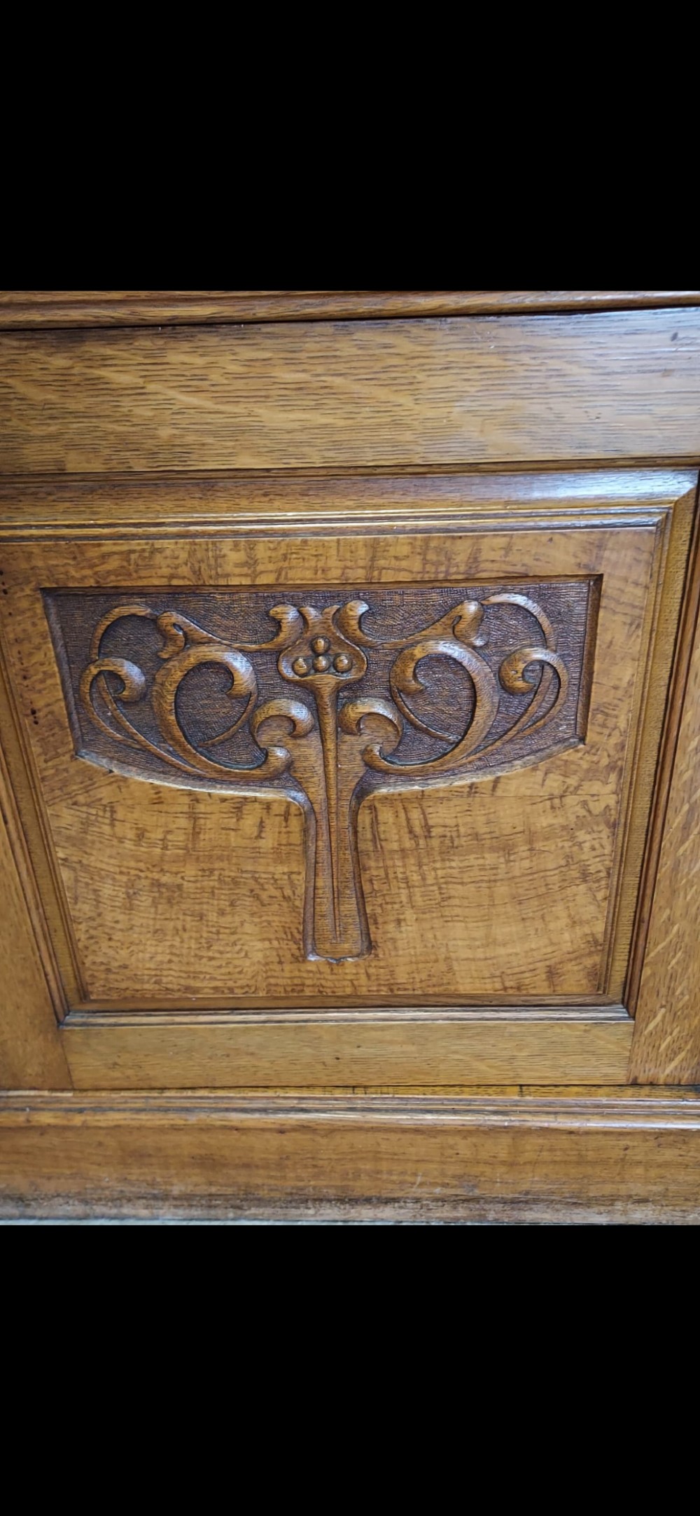 A late 19th-century oak bookcase featuring two glazed upper doors, two waist drawers, and stylised carved relief motifs on the lower cupboard doors. View XII