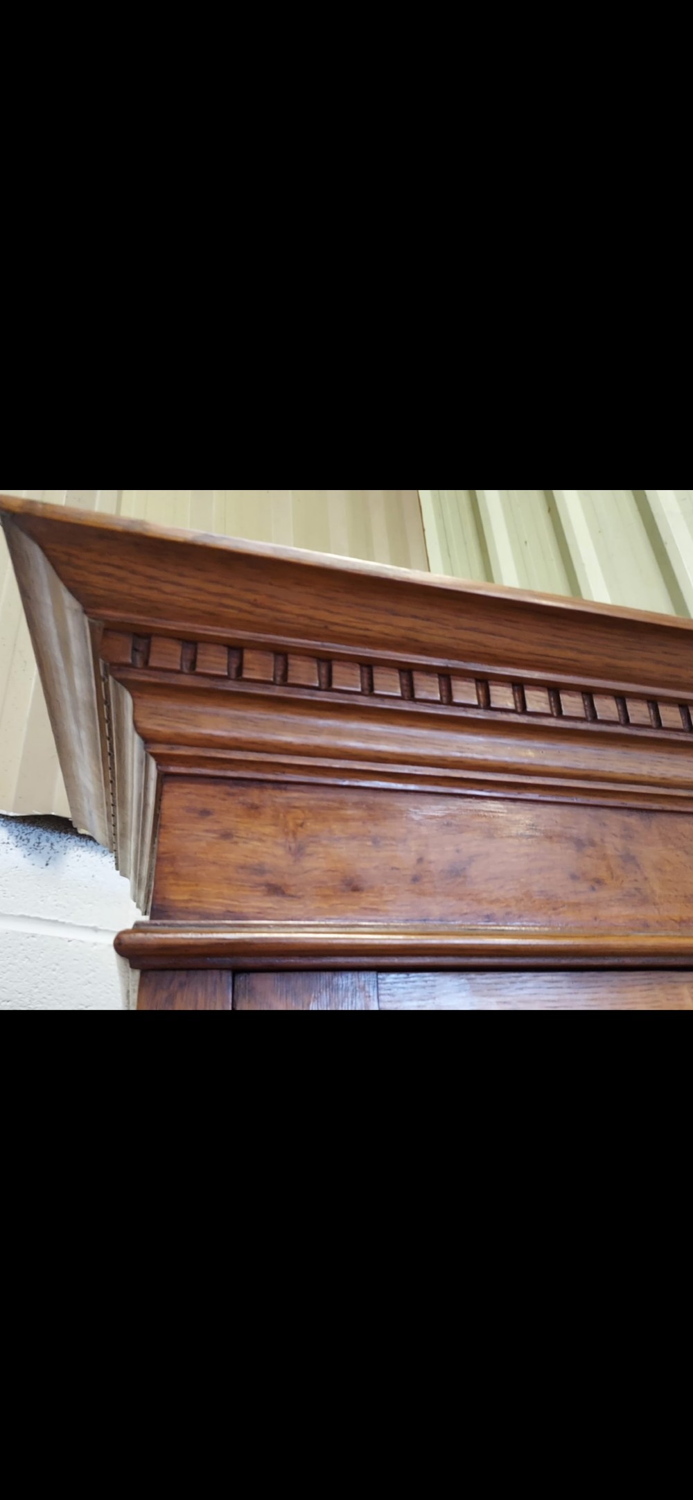 A late 19th-century oak bookcase featuring two glazed upper doors, two waist drawers, and stylised carved relief motifs on the lower cupboard doors. View XIII