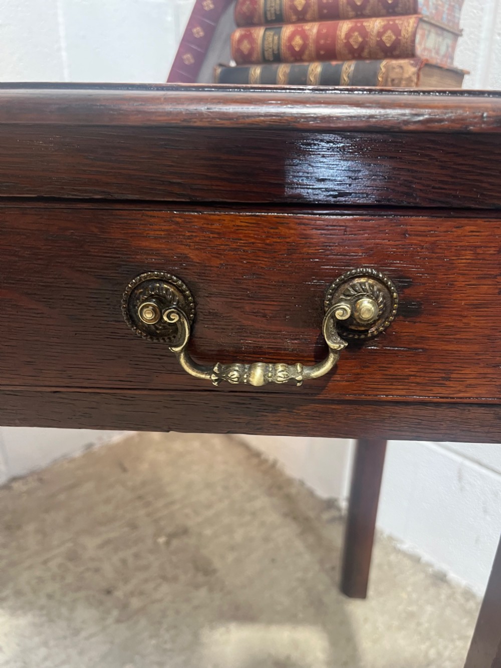 An early nineteenth-century dark oak side table featuring a single frieze drawer with brass drop handles and straight square legs. View X