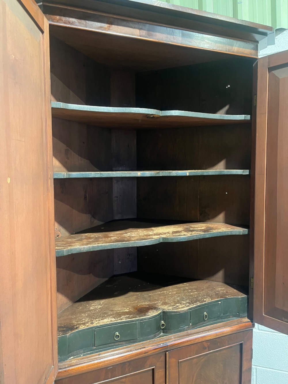 A tall Georgian floor-standing corner cupboard crafted from dark flame mahogany with upper and lower double-panelled doors and brass escutcheons. View VIII