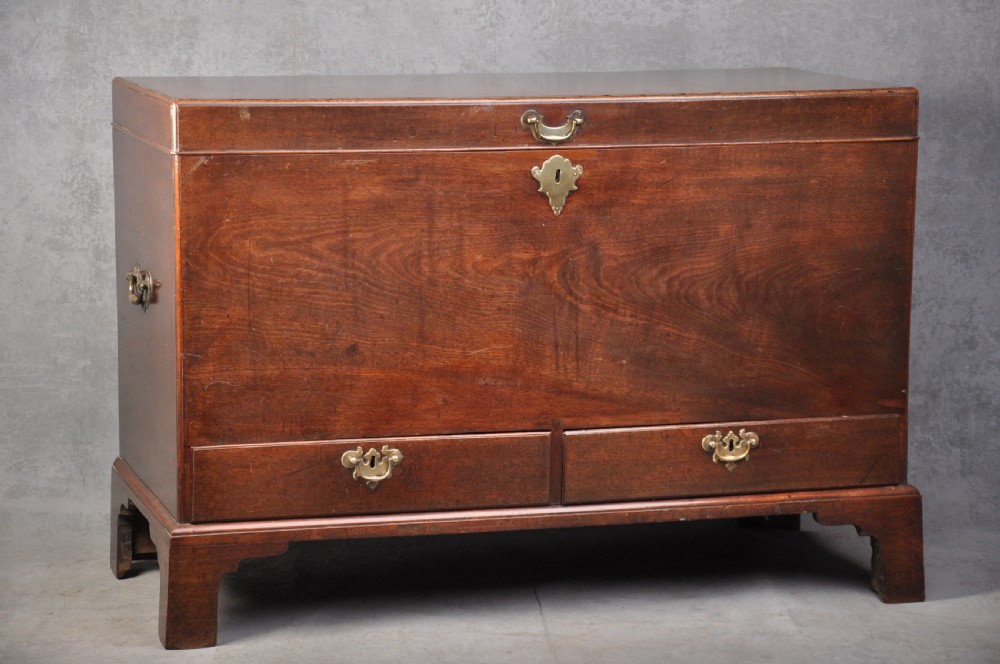 An 18th-century mahogany silver chest featuring a hinged lid, twin base drawers, side carrying handles, and bracket feet.