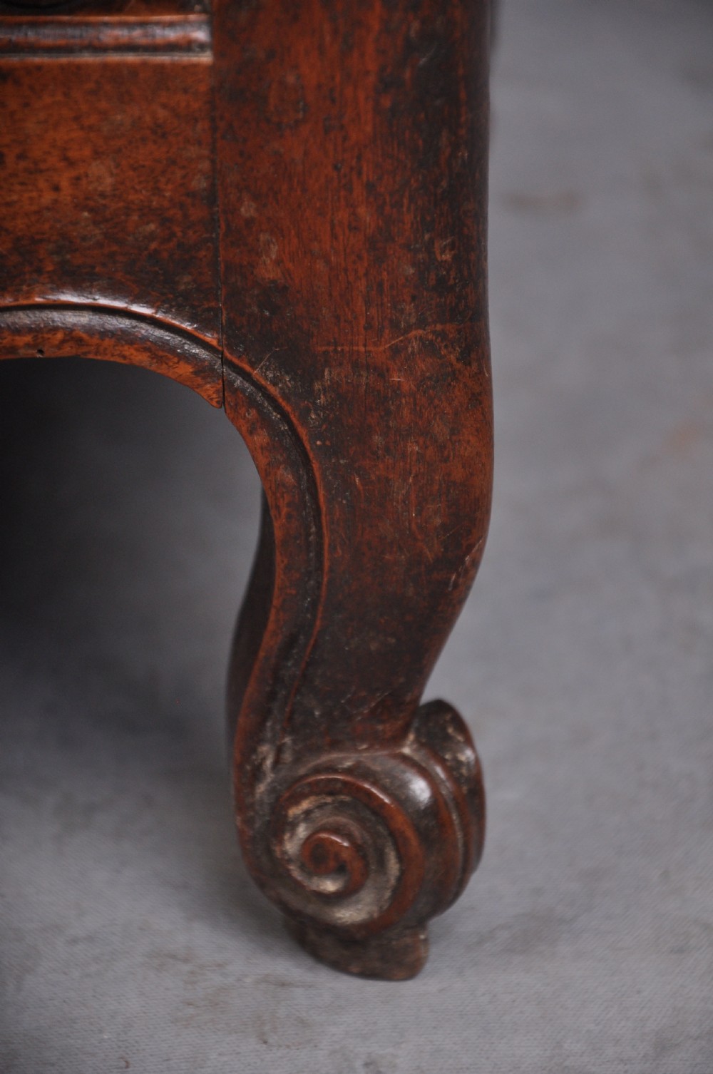 An 18th-century carved walnut French panettiere featuring turned wooden spindles, a central door with carved urn motifs, top finials, and short cabriole legs. View V