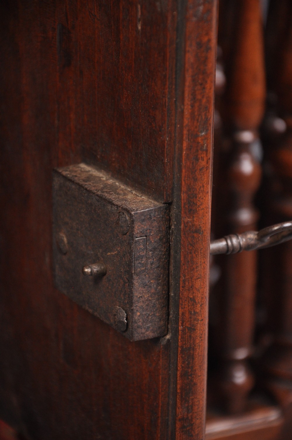 An 18th-century carved walnut French panettiere featuring turned wooden spindles, a central door with carved urn motifs, top finials, and short cabriole legs. View VII