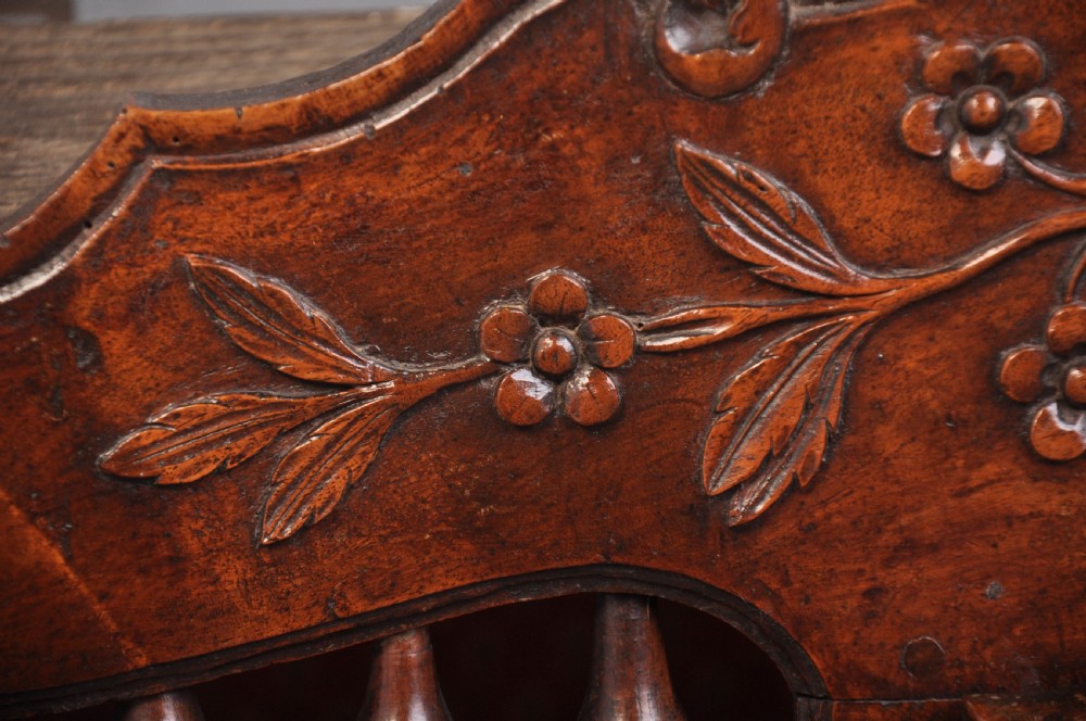 An 18th-century carved walnut French panettiere featuring turned wooden spindles, a central door with carved urn motifs, top finials, and short cabriole legs. View VIII