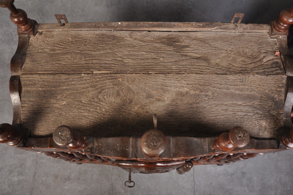 An 18th-century carved walnut French panettiere featuring turned wooden spindles, a central door with carved urn motifs, top finials, and short cabriole legs. View XI