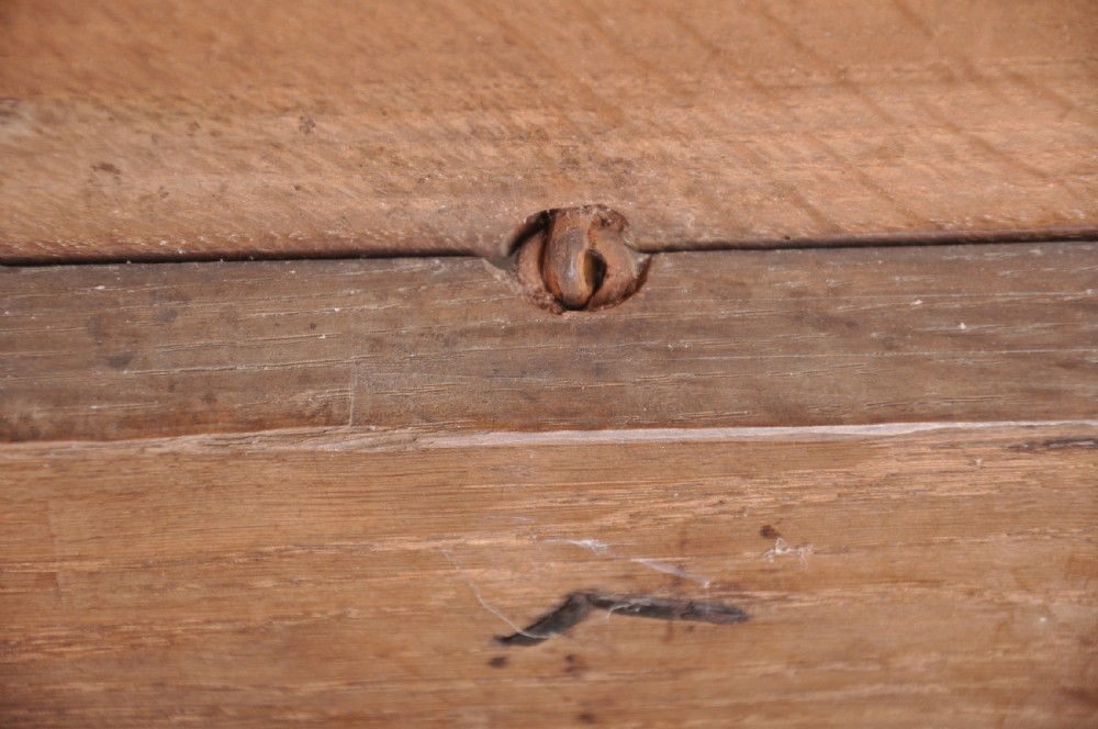 A seventeenth-century dark oak coffer featuring three carved front panels with scrolling leaf motifs, a lunette frieze, and an iron lockplate. View VI