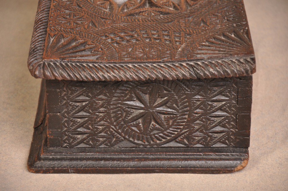 A rectangular dark oak box with geometric star chip carvings across the lid and front face, featuring a central iron keyhole. View III