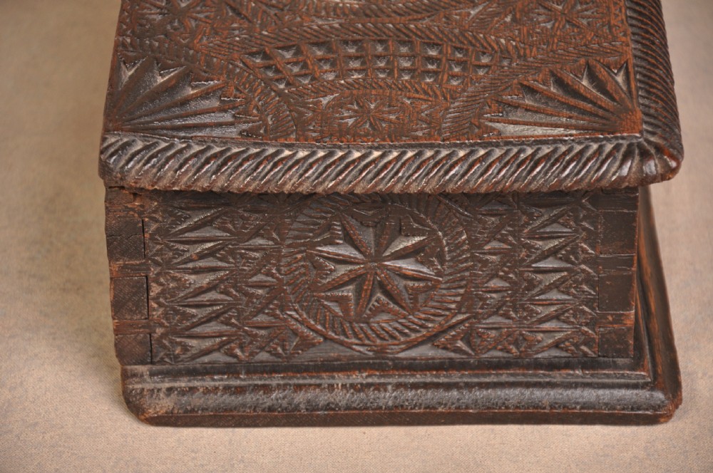 A rectangular dark oak box with geometric star chip carvings across the lid and front face, featuring a central iron keyhole. View IV