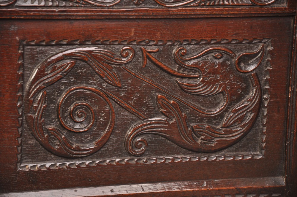 A 17th-century carved oak coffer featuring relief-carved front panels and a dark aged patina. View II