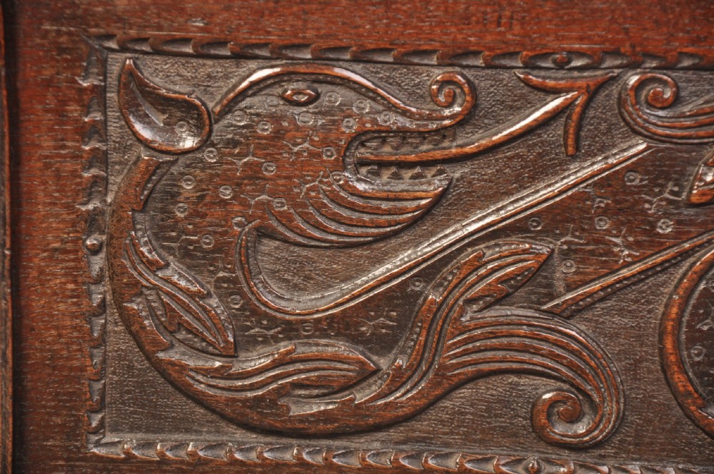A 17th-century carved oak coffer featuring relief-carved front panels and a dark aged patina. View IV