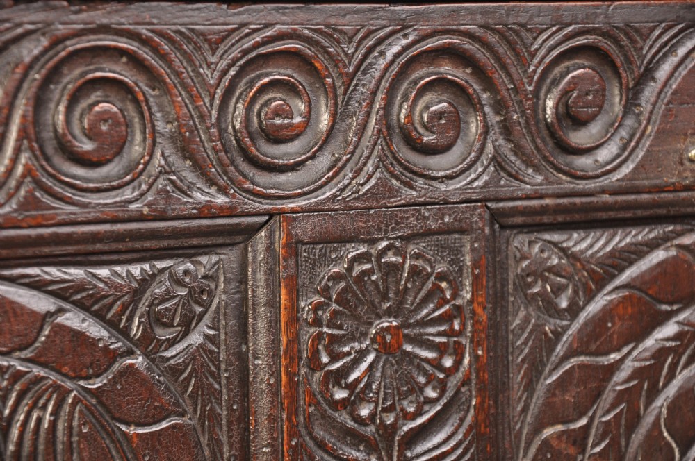 A seventeenth-century carved dark oak Yorkshire coffer featuring three arcaded floral panels, scrollwork friezes, two lower drawers, and brass keyhole escutcheons. View VIII